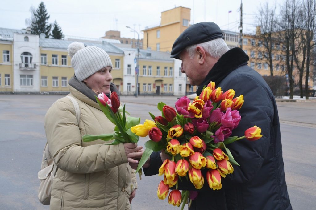 На улице дарят цветы. Женщинам дарят цветы на 8 арта.
