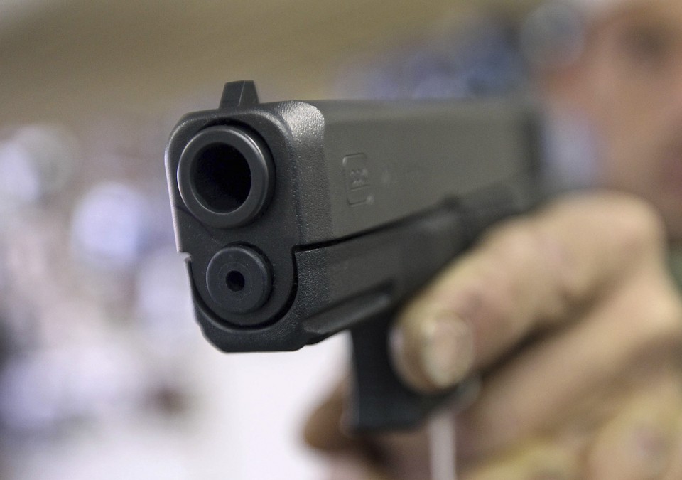 A customer tests a Glock 20 10mm handgun at the Guns-R-Us gun shop in Phoenix, Arizona