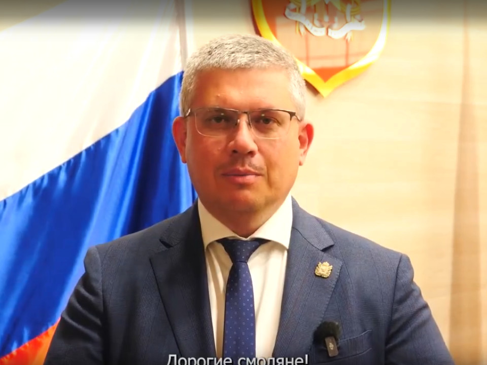 Новиков на фоне флага России, герба Смоленска
